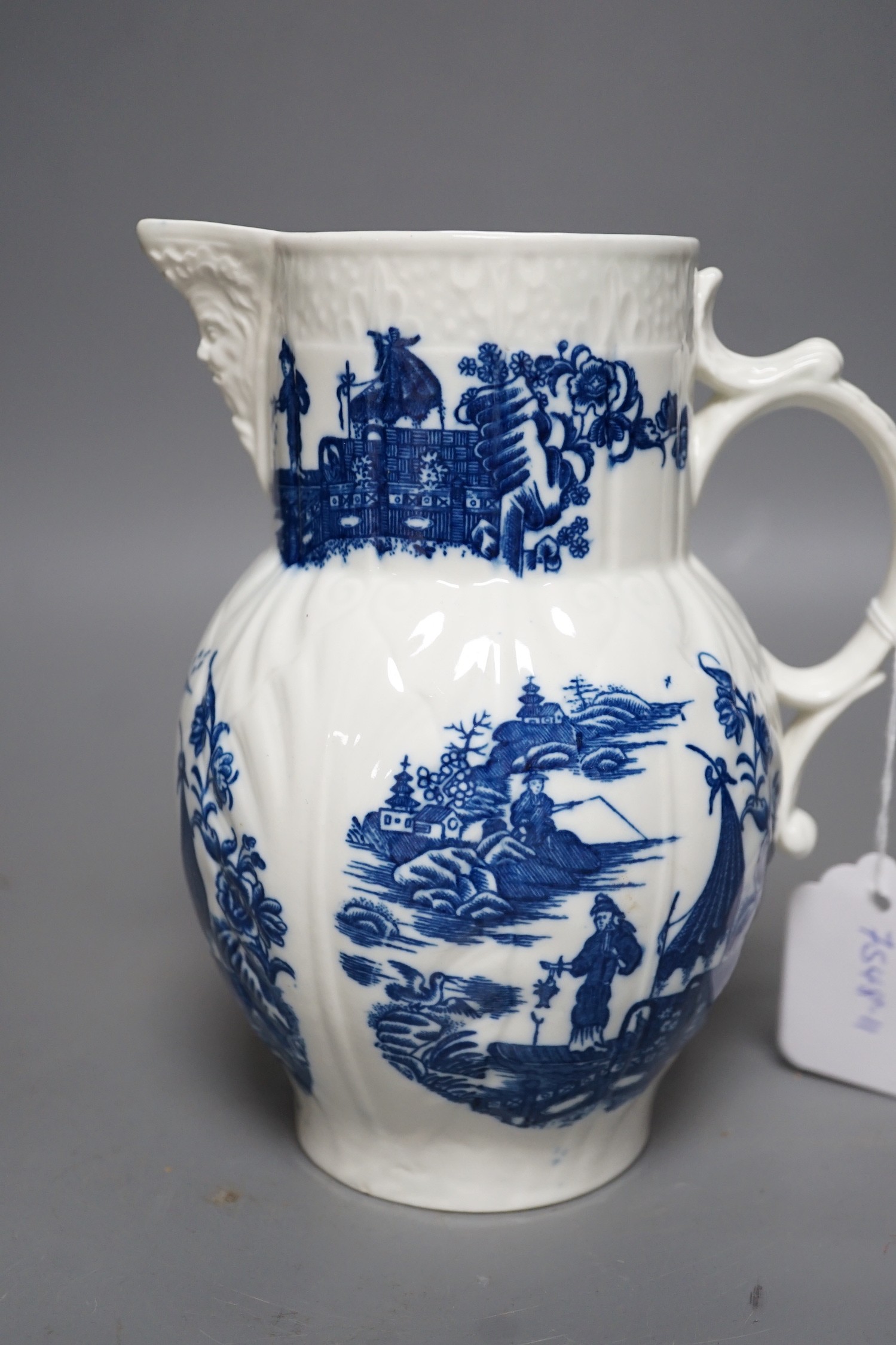 A Caughley baluster mask jug of cabbage leaf moulded shape, printed in underglaze blue with five landscapes of the Fisherman, Sx mark, 19cms high